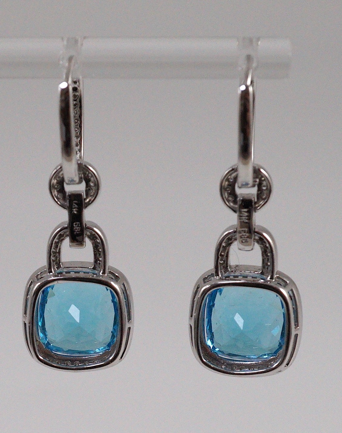 A modern pair of 14kt white gold, blue topaz and diamond chip set drop earrings